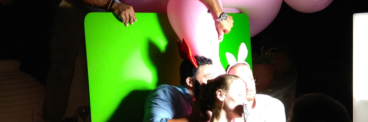 The guests are photographed with inflantable flamingos at the Smileme Photobooth at a wedding in Paxos (Paxoi)
